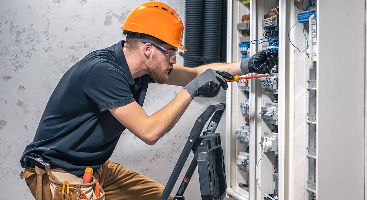 Electrician adjusting curcuit board with tool