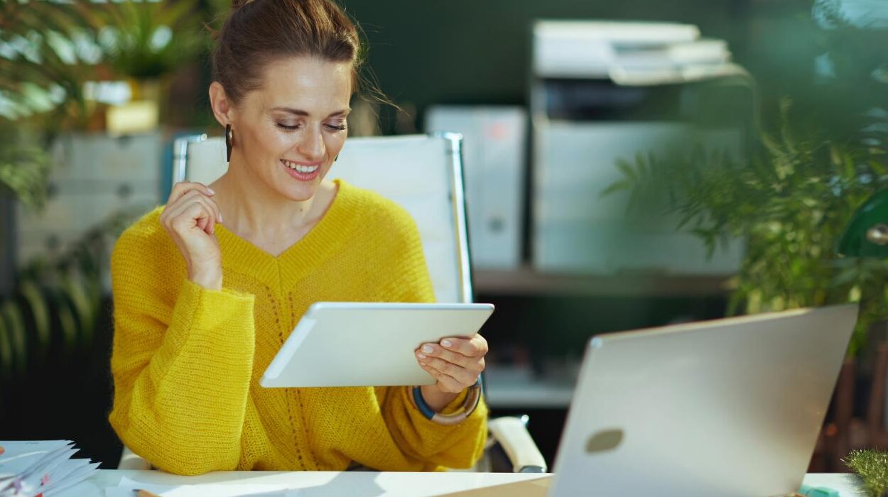 Woman doing accounts admin on tablet and laptop